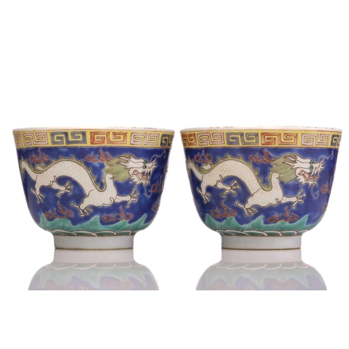 175 - A pair of Chinese porcelain dragon cups, painted with opposing white dragons facing a pearl amongst ... 