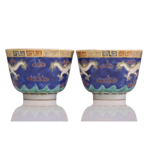 175 - A pair of Chinese porcelain dragon cups, painted with opposing white dragons facing a pearl amongst ... 