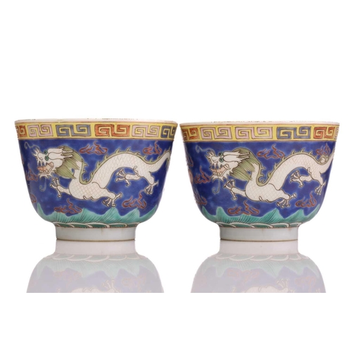 175 - A pair of Chinese porcelain dragon cups, painted with opposing white dragons facing a pearl amongst ... 