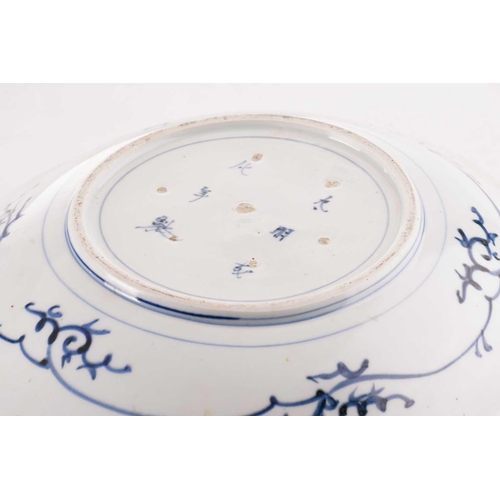 179 - A Japanese blue & white dish, 18th/19th century, painted with a landscape, with a shaped rim, the un... 