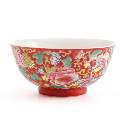 205 - A Chinese porcelain bowl, painted with butterflies amongst flower and leafy tendrils against a red g... 