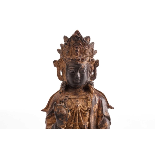 211 - A Chinese bronze figure of Guanyin, in the Ming style, seated in vitarka mudra upon a temple lion on... 