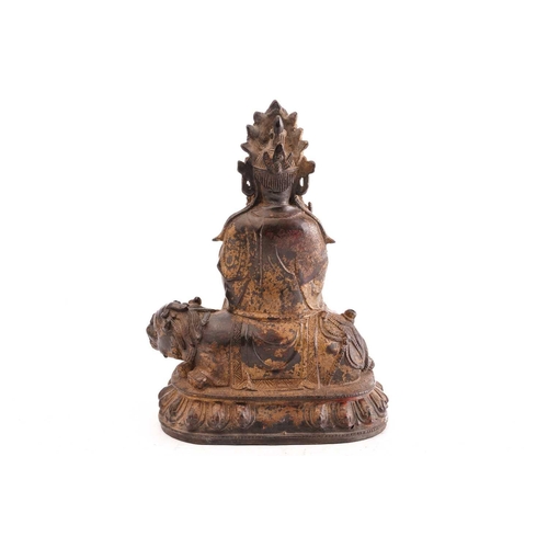 211 - A Chinese bronze figure of Guanyin, in the Ming style, seated in vitarka mudra upon a temple lion on... 