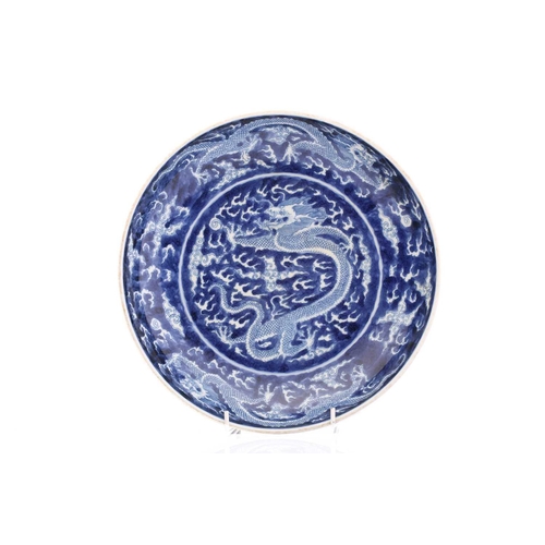 220 - A Chinese porcel;ain blue & white dragon dish, painted with a central dragon bordered by two further... 