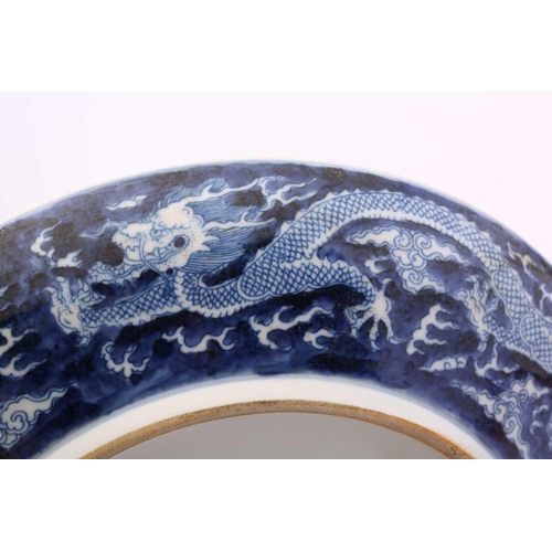 220 - A Chinese porcel;ain blue & white dragon dish, painted with a central dragon bordered by two further... 