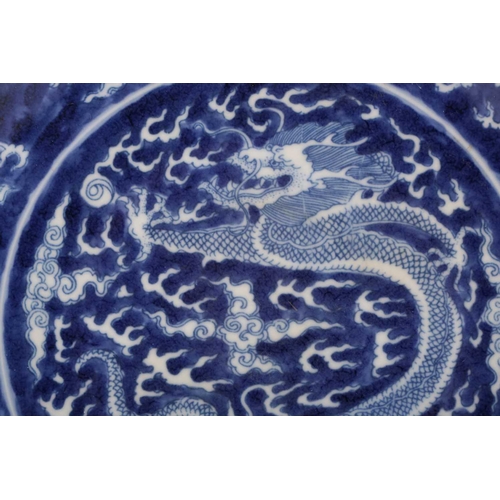 220 - A Chinese porcel;ain blue & white dragon dish, painted with a central dragon bordered by two further... 