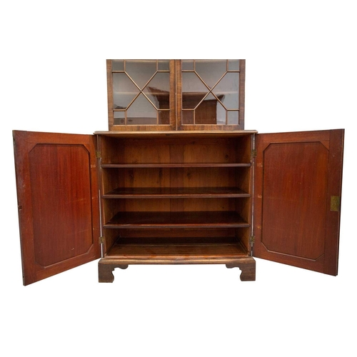 308 - A George III mahogany cupboard bookcase with a carved and lattice worked swan neck pediment above a ... 