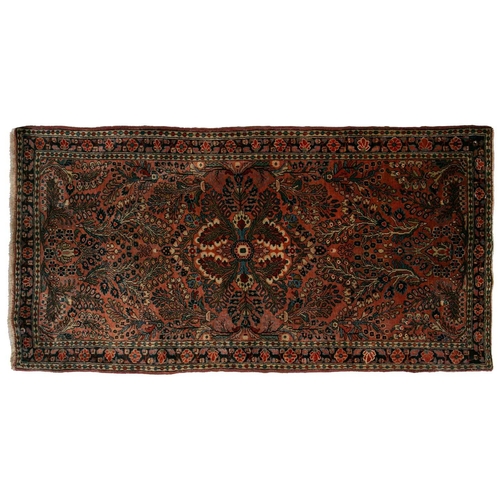 320 - A small Sarouk rug with a distinctive pink ground with a central medallion and sprays of flowers wit... 