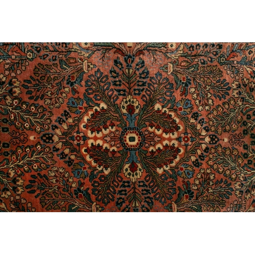 320 - A small Sarouk rug with a distinctive pink ground with a central medallion and sprays of flowers wit... 