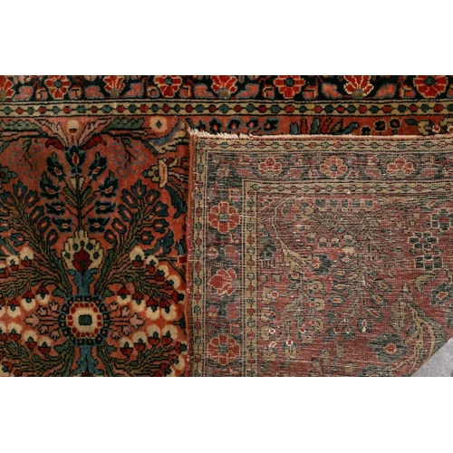 320 - A small Sarouk rug with a distinctive pink ground with a central medallion and sprays of flowers wit... 