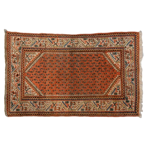 320 - A small Sarouk rug with a distinctive pink ground with a central medallion and sprays of flowers wit... 