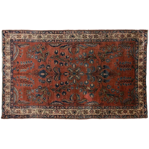 321 - An old silk Kashan rug with stylized shrubs and flowers on a dark brick red ground, within meanderin... 