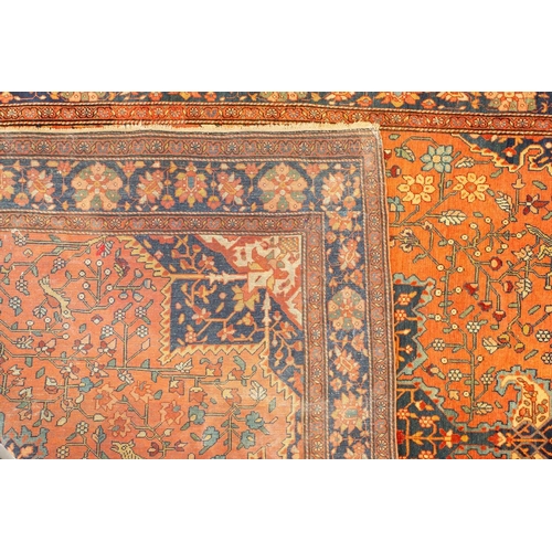 326 - An old Tabriz rug with a central star motif with hanging lanterns and animals and shrubs on crimson ... 