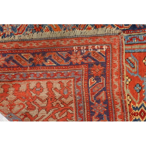 331 - An old Turkish Ushak rug with a stylized tree of life design on a tomato red ground within multiple ... 