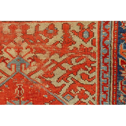 331 - An old Turkish Ushak rug with a stylized tree of life design on a tomato red ground within multiple ... 