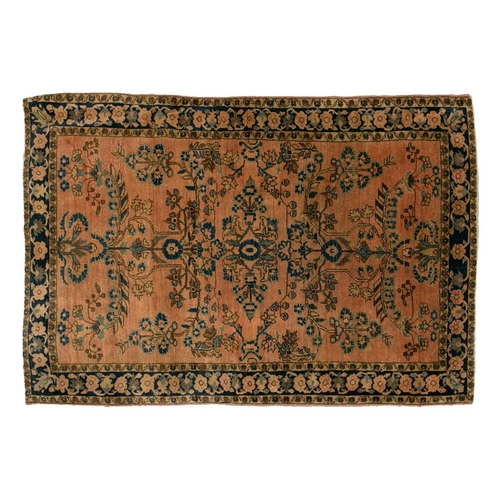 332 - An old Sarouk rug with floral sprays on a typical dusky pink ground within a meandering indigo groun... 