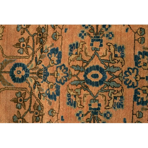 332 - An old Sarouk rug with floral sprays on a typical dusky pink ground within a meandering indigo groun... 