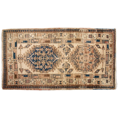 333 - An old possibly North West Persian tribal rug with two lozenges on a faded ivory ground, 165 cm x 90... 