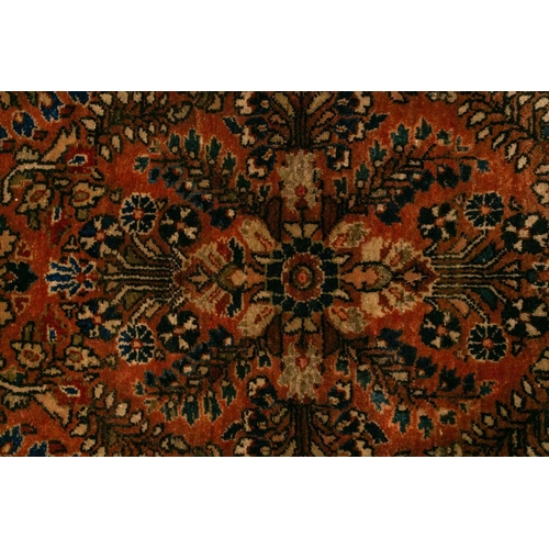 334 - An old sarouk rug with a central medallion and floral sprays on a salmon pink ground. within floral ... 