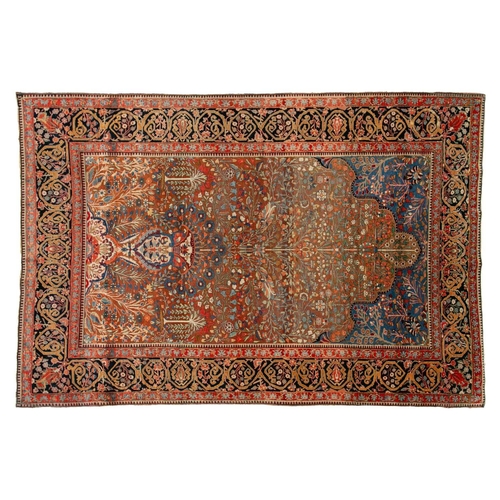 335 - An old Motashemi Kashan rug with a flowering urn issuing from an urn on a brick red ground within a ... 