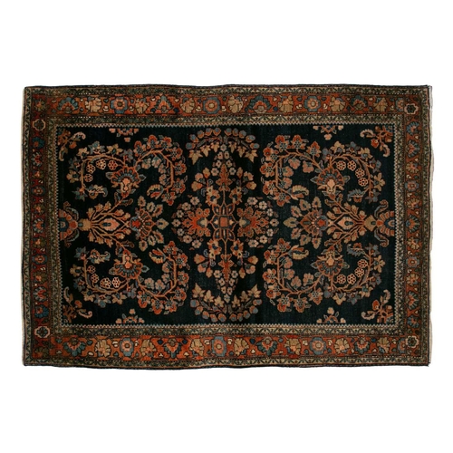 336 - An old Sarouk rug with floral sprays on an indigo blue ground within floral borders. 145 cm x 100 cm