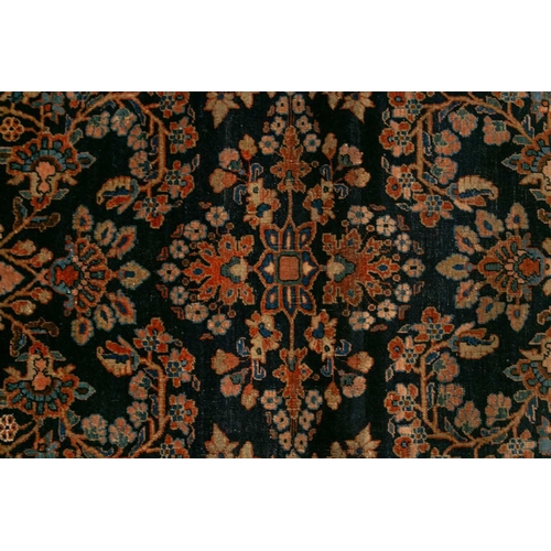 336 - An old Sarouk rug with floral sprays on an indigo blue ground within floral borders. 145 cm x 100 cm