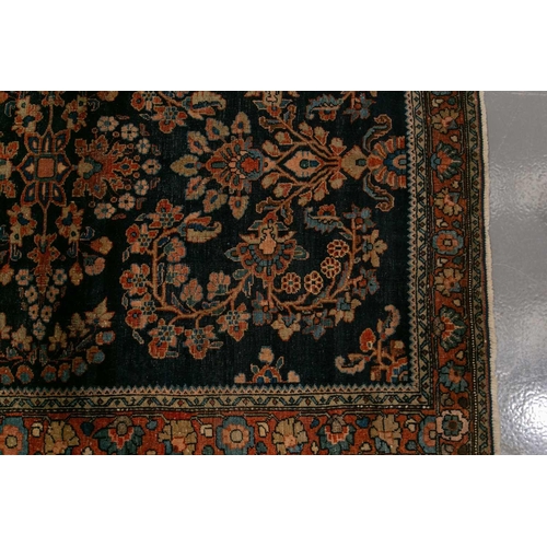 336 - An old Sarouk rug with floral sprays on an indigo blue ground within floral borders. 145 cm x 100 cm