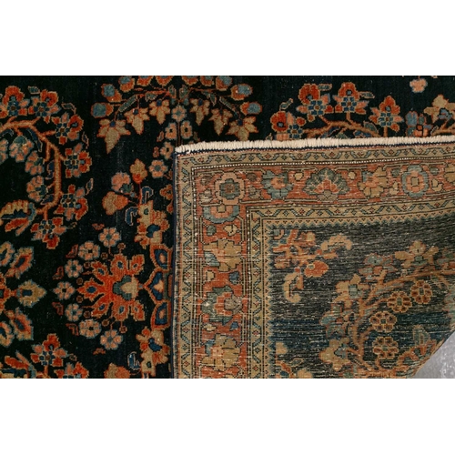 336 - An old Sarouk rug with floral sprays on an indigo blue ground within floral borders. 145 cm x 100 cm