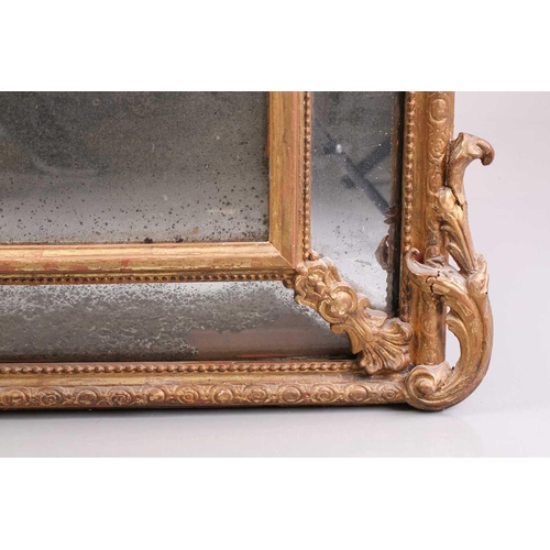 342 - A 19th-century giltwood wall mirror, the scroll carved crest over a beaded frame and protruding rect... 