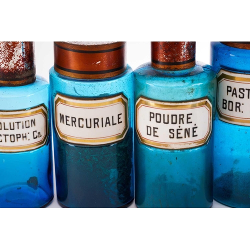 377 - Thirteen French blue glass apothecary jars, with white porcelain labels and tin lids, tallest 25 cm ... 