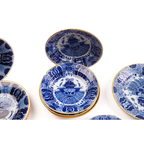 409 - Five 18th century Dutch Delft plates, depciting a figure on a bridge beside a pagoda, within a panel... 