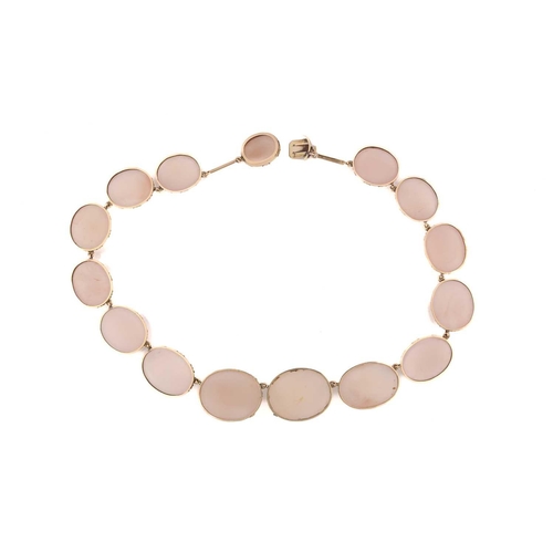 101 - An Edwardian rose quartz rivière necklace, containing fifteen graduated rose quartz cabochons in col... 