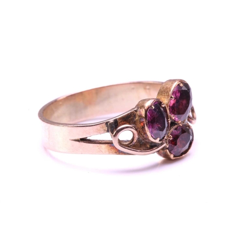 110 - A Ruby and Garnet floral ring, formed from two Garnets claw set with a Ruby into a petal form on a y... 