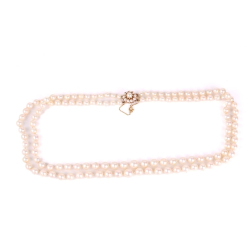 113 - A necklace with a double row of pearls, comprising two strands of cream-coloured cultured pearls gra... 