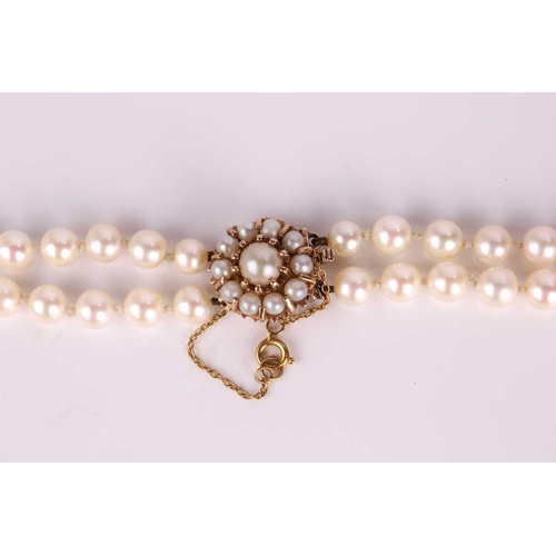 113 - A necklace with a double row of pearls, comprising two strands of cream-coloured cultured pearls gra... 