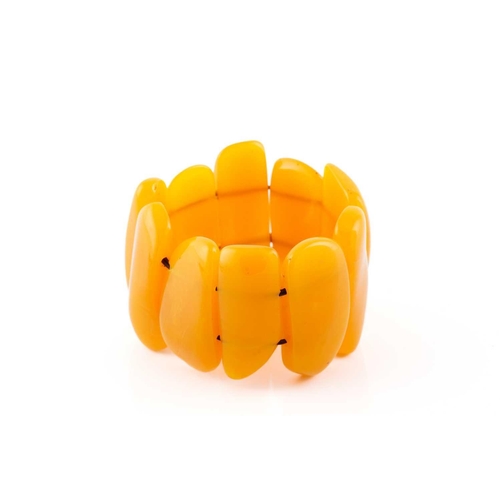 119 - An egg yolk amber panel bracelet; of ten shaped oval and rectangular panels. 100 grams