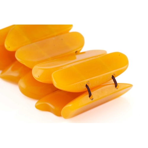 119 - An egg yolk amber panel bracelet; of ten shaped oval and rectangular panels. 100 grams