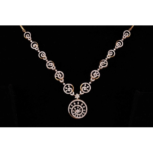 12 - A diamond-set necklace and earrings suite, of swirl designs; the necklace comprises a circular motif... 