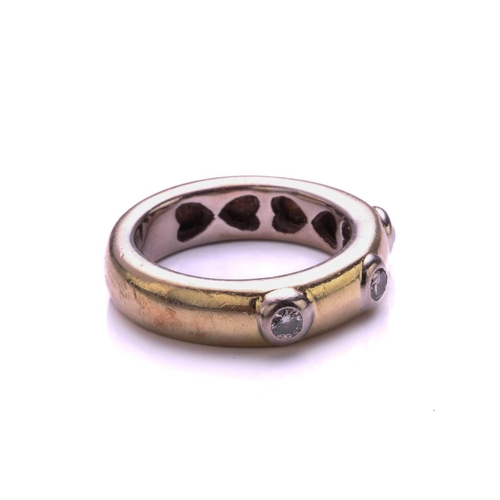 124 - A three stone half hoop diamond ring; the round brilliant cut diamonds in raised rub over mounts wit... 