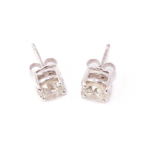 133 - A pair of diamond stud earrings in 18ct white gold, each featuring a round brilliant-cut diamond wit... 