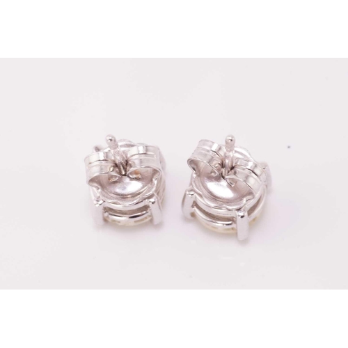 133 - A pair of diamond stud earrings in 18ct white gold, each featuring a round brilliant-cut diamond wit... 