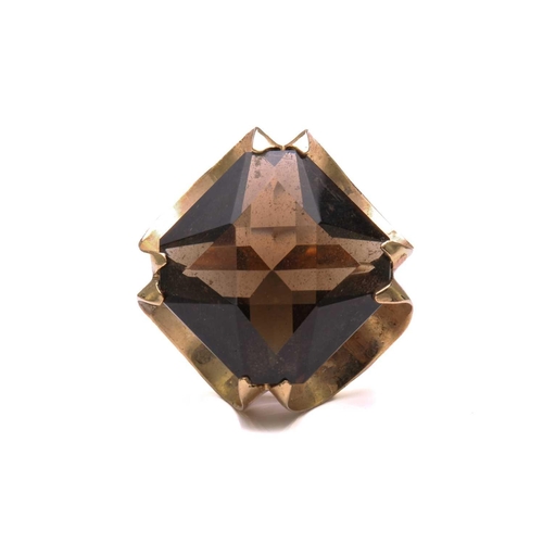 147 - A smoky quartz dress ring in 9ct yellow gold, composed of an octagonal modified scissors-cut smoky q... 