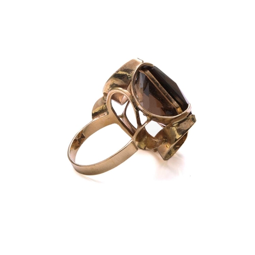 147 - A smoky quartz dress ring in 9ct yellow gold, composed of an octagonal modified scissors-cut smoky q... 