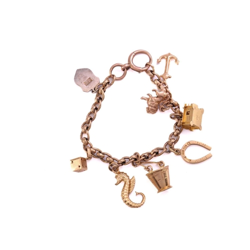 153 - A 9ct gold charm bracelet, consisting of a curb chain with faceted intervals, attached with a collec... 