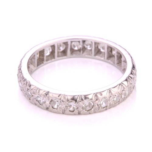 156 - A diamond eternity ring in platinum, illusion-set with an array of circular single-cut diamonds, Lon... 