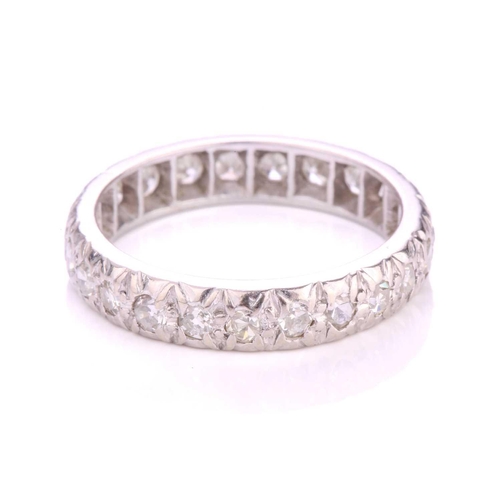 156 - A diamond eternity ring in platinum, illusion-set with an array of circular single-cut diamonds, Lon... 