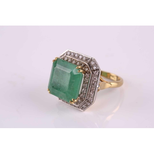 159 - An emerald and diamond cluster ring, featuring a step-cut emerald with a translucent light green-col... 