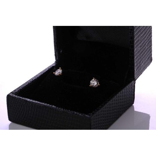 192 - A pair of diamond earrings, each comprising a round brilliant cut diamond in a three-claw setting, a... 