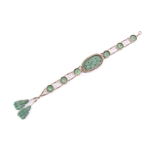 20 - A carved jade and pearl bracelet, featuring an elongated oval jadeite plaque in a greyish-green colo... 