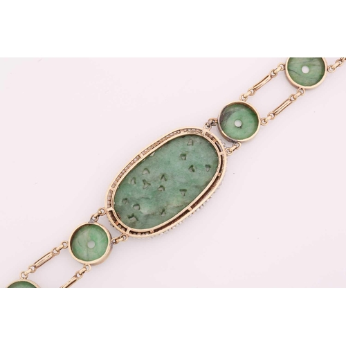 20 - A carved jade and pearl bracelet, featuring an elongated oval jadeite plaque in a greyish-green colo... 